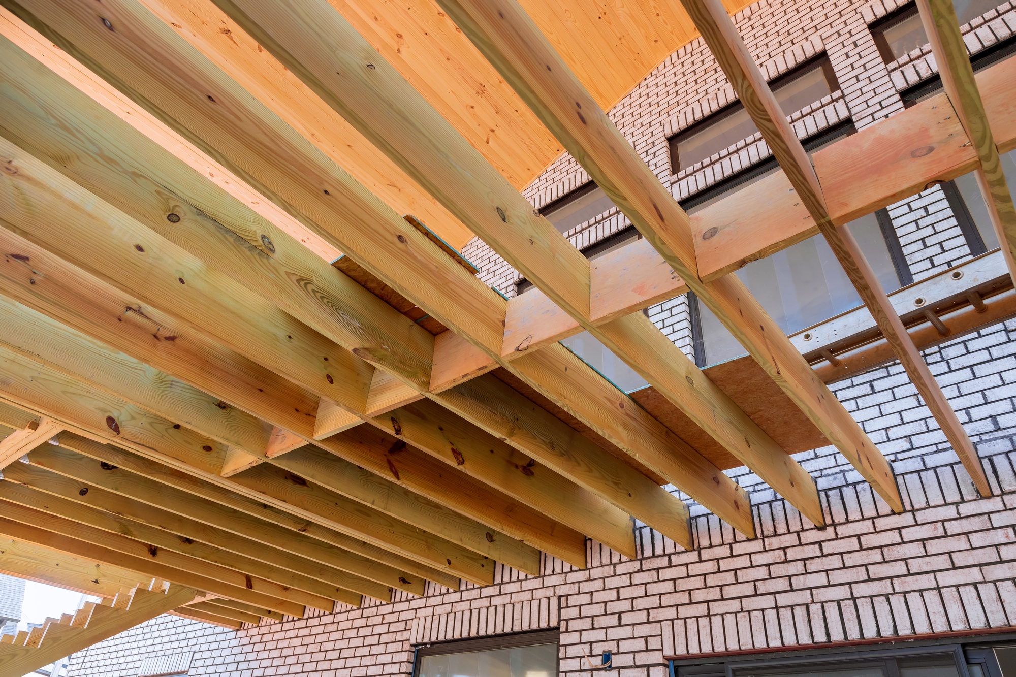 At a new custom home, the flooring joists have been laid out for the wooden deck patio in accordance